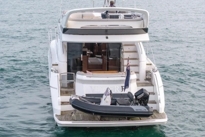 Luxury 2017 Princess 52 yacht with tender on water, rear view.