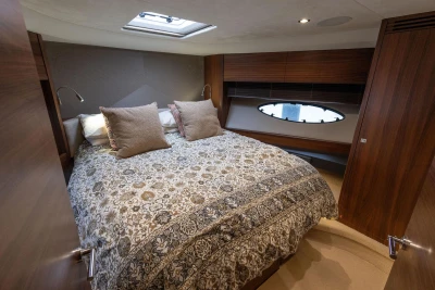Luxurious bedroom interior of 2017 Princess 52 yacht with elegant bedding and wood accents.
