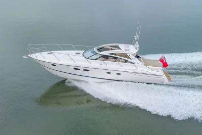 2006 Princess V48 yacht cruising on calm waters with a red flag.