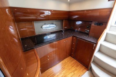 Luxurious kitchen interior of 2006 Princess V48 yacht with wood cabinetry and modern appliances.