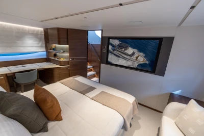 Luxurious cabin interior of 2026 Princess Y72 yacht with modern decor and large screen.