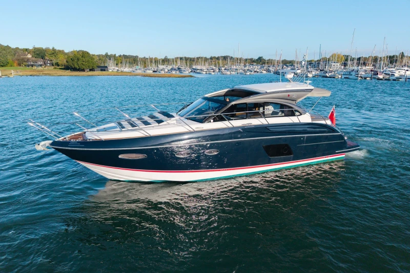 2014 Princess V48 yacht cruising on a sunny day near a marina.