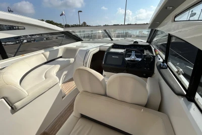 Luxurious 2012 Princess V42 yacht interior with plush seating and modern helm.