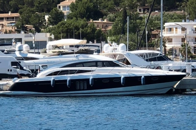 Luxury 2006 Princess 58 yacht docked in a marina, surrounded by other boats.
