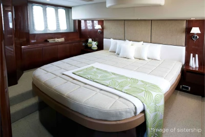 Luxurious bedroom interior of a 2006 Princess 58 yacht with elegant bedding and wood accents.