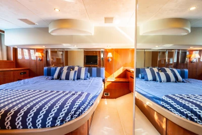 Luxurious cabin interior of 2008 Princess 58 yacht with elegant bedding and wood finishes.