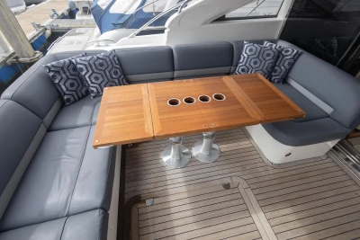 Luxurious 2012 Princess V52 yacht deck with cushioned seating and wooden table.