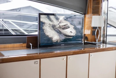 Interior of 2012 Princess V52 yacht with TV displaying a boat on water.