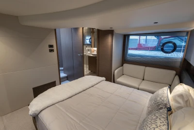 Luxurious 2022 Princess V50 yacht bedroom with modern decor and comfortable seating.