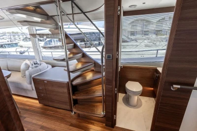 Luxurious interior of 2026 Princess X80 yacht with wooden staircase and modern bathroom.