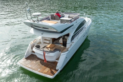 Luxury 2016 Princess 43 yacht cruising on calm waters, rear view.