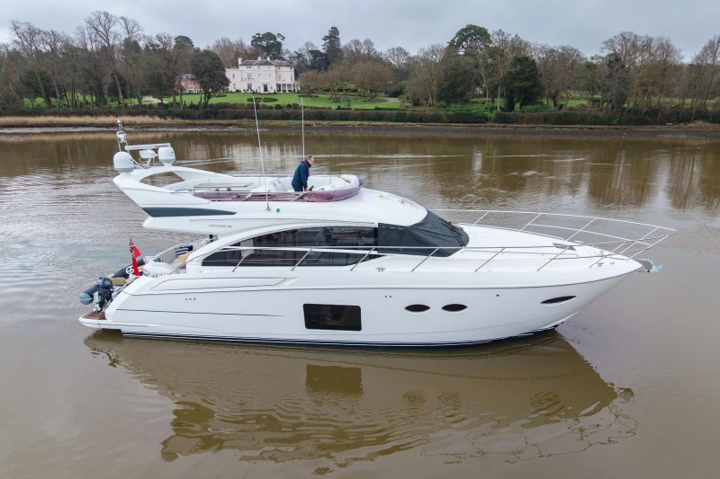 2017 Princess 52 yacht cruising on a calm river with scenic background.