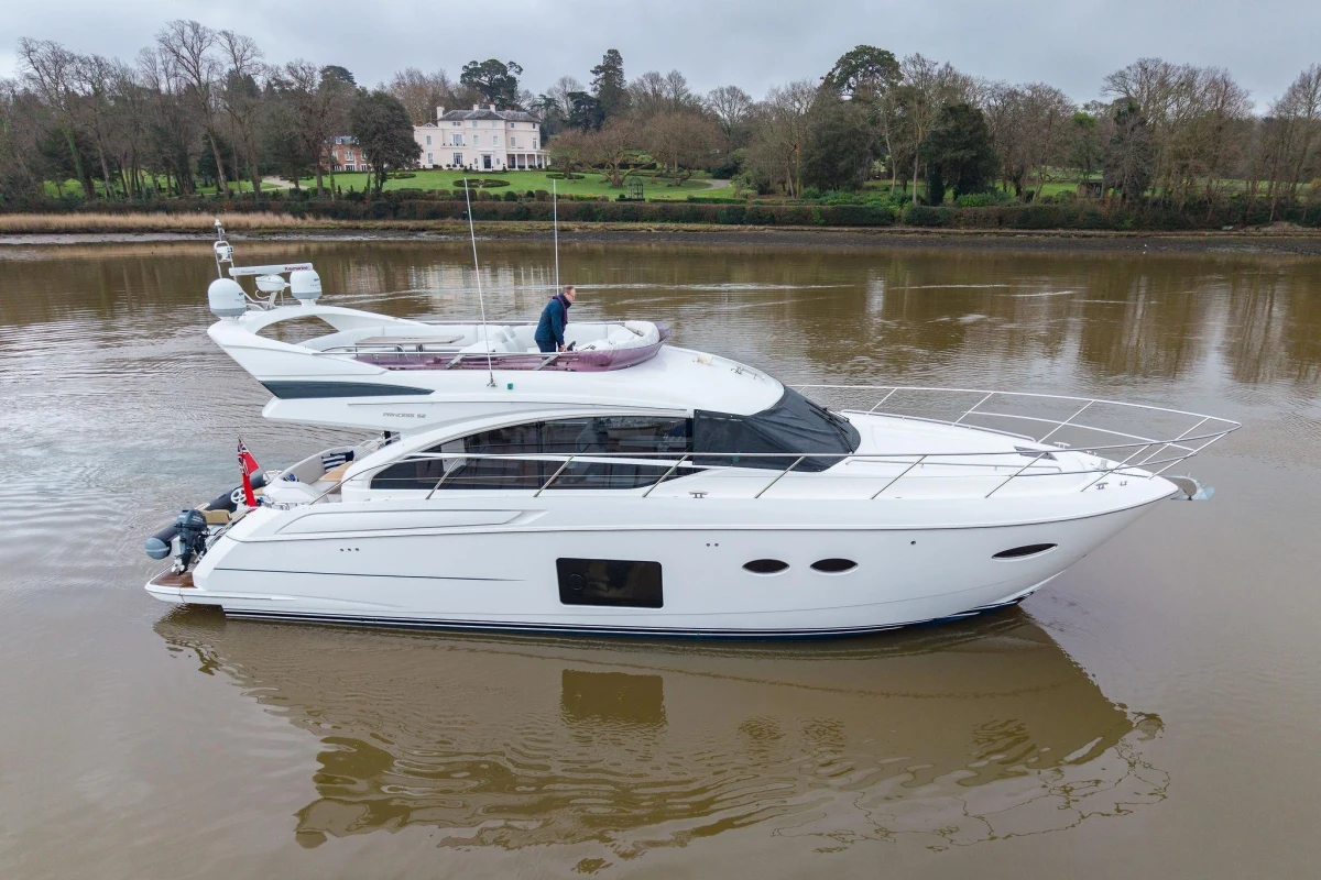 2017 Princess 52 yacht cruising on a calm river with scenic background.