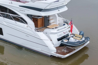 Luxury 2017 Princess 52 yacht with tender, docked on calm water.