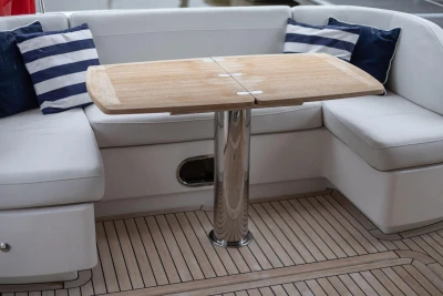 Luxurious seating area on 2017 Princess 52 yacht with wooden table and striped cushions.