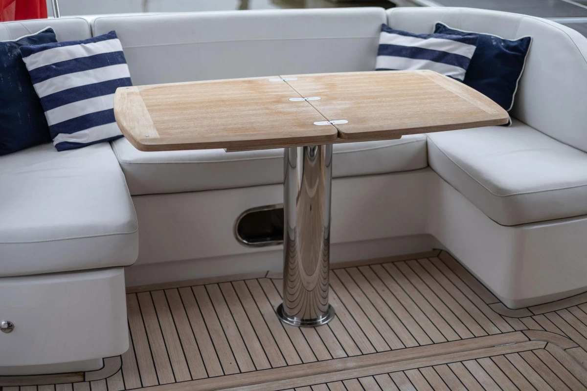Luxurious seating area on 2017 Princess 52 yacht with wooden table and striped cushions.