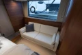 Luxurious interior of 2017 Princess 52 yacht with elegant white sofa and wooden accents.