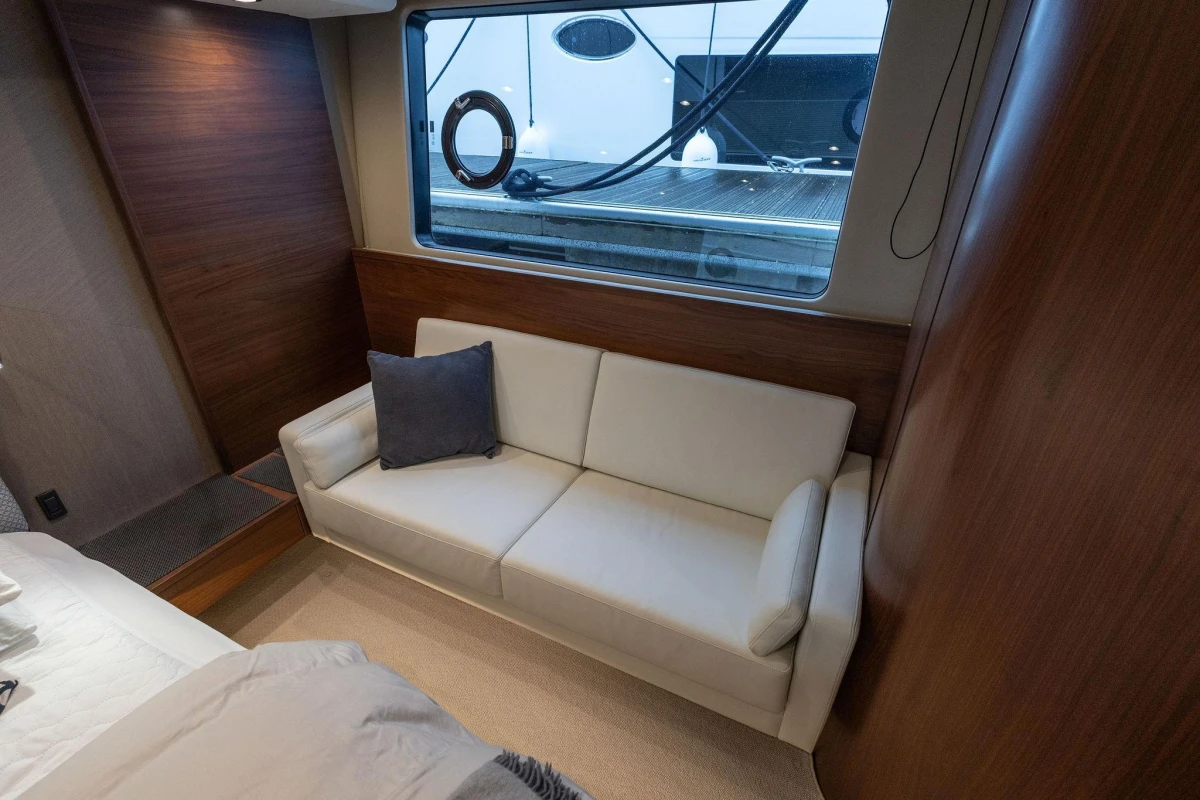 Luxurious interior of 2017 Princess 52 yacht with elegant white sofa and wooden accents.