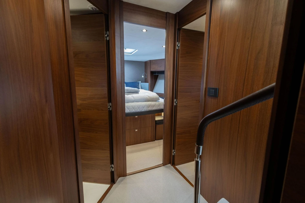 Luxurious interior of 2017 Princess 52 yacht with wood paneling and cozy bedroom.