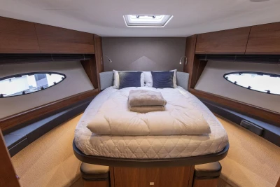 Luxurious cabin interior of 2017 Princess 52 yacht with cozy bed and elegant wood finish.