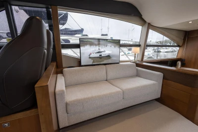 Luxurious interior of 2017 Princess 52 yacht with sofa and marina view.