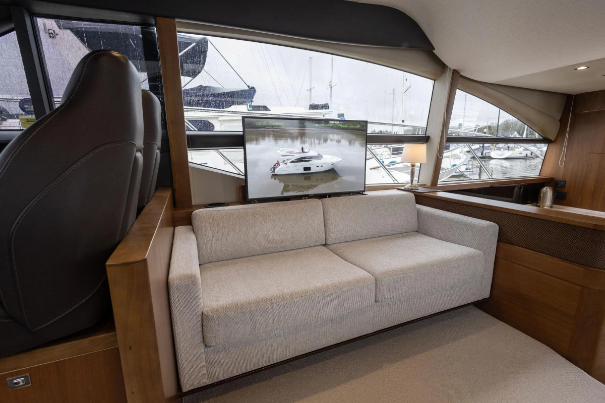 Luxurious interior of 2017 Princess 52 yacht with sofa and marina view.
