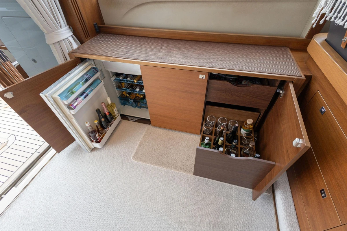 Luxurious 2017 Princess 52 yacht interior with open fridge and storage cabinets.