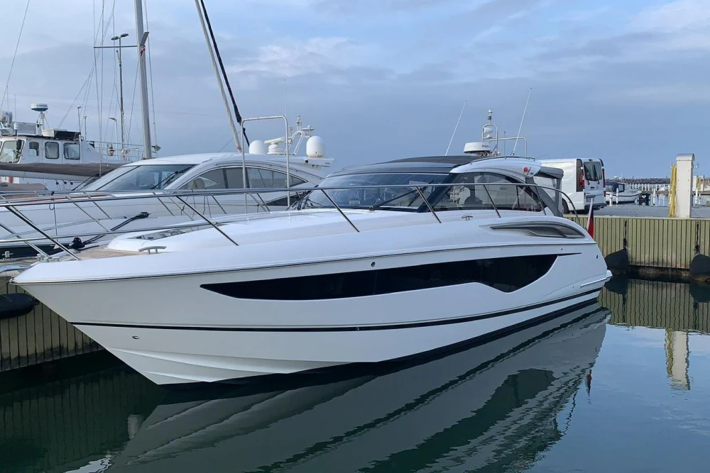 2017 Princess V40 yacht docked at marina, sleek design, calm water reflection.