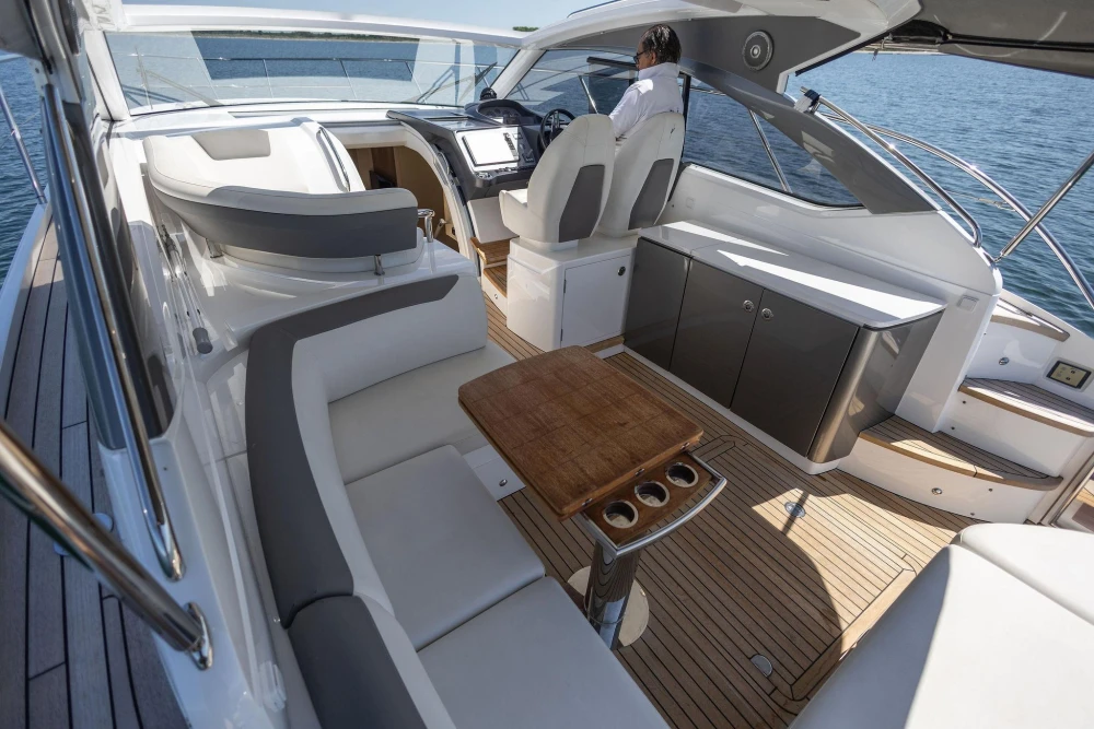 Luxurious 2017 Princess V40 yacht interior with elegant seating and wooden table on open water.