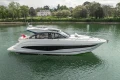 2025 Princess V50 yacht cruising on a serene river with lush greenery in the background.
