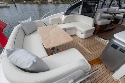 Luxurious seating area on 2025 Princess V50 yacht with elegant wooden table and cushions.