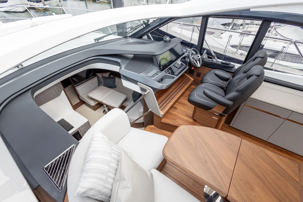Luxurious 2025 Princess V50 yacht interior with modern helm, seating, and wooden finishes.