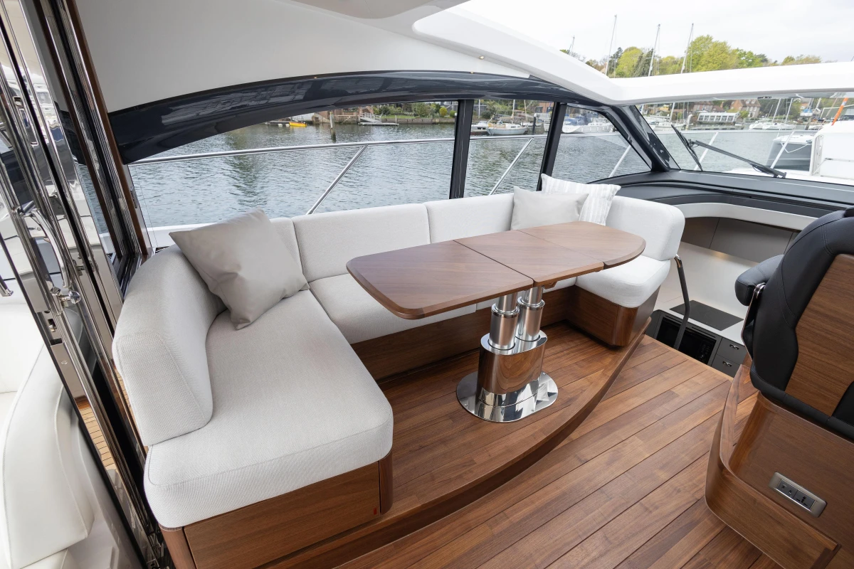Luxurious interior of 2025 Princess V50 yacht with elegant seating and wooden table.