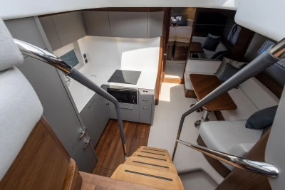 Luxurious interior of 2025 Princess V50 yacht, featuring modern kitchen and cozy seating area.