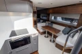 Luxurious interior of 2025 Princess V50 yacht with modern kitchen and cozy seating area.