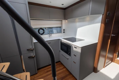 Modern kitchen interior on 2025 Princess V50 yacht, featuring sleek cabinetry and appliances.