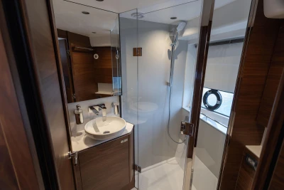 Luxurious bathroom in 2025 Princess V50 yacht with modern fixtures and glass shower.