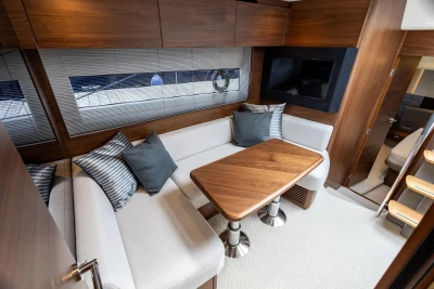 Luxurious interior of 2025 Princess V50 yacht with elegant seating and wooden table.