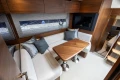 Luxurious interior of 2025 Princess V50 yacht with elegant seating and wooden table.