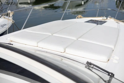 Sunbathing cushions on a 2015 Princess V39 yacht deck, docked at a marina.