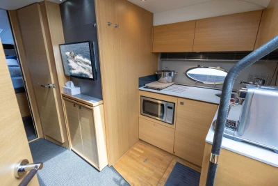 Modern kitchen interior of 2015 Princess V39 yacht with wooden cabinetry and appliances.