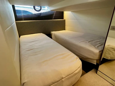 2024 Princess V40 yacht cabin with twin beds, modern design, and soft lighting.