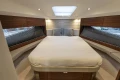 Luxurious interior of 2024 Princess V40 yacht with elegant wood finishes and cozy bedding.