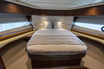 Luxurious bedroom interior of 2025 Princess S65 yacht with elegant wood finishes.