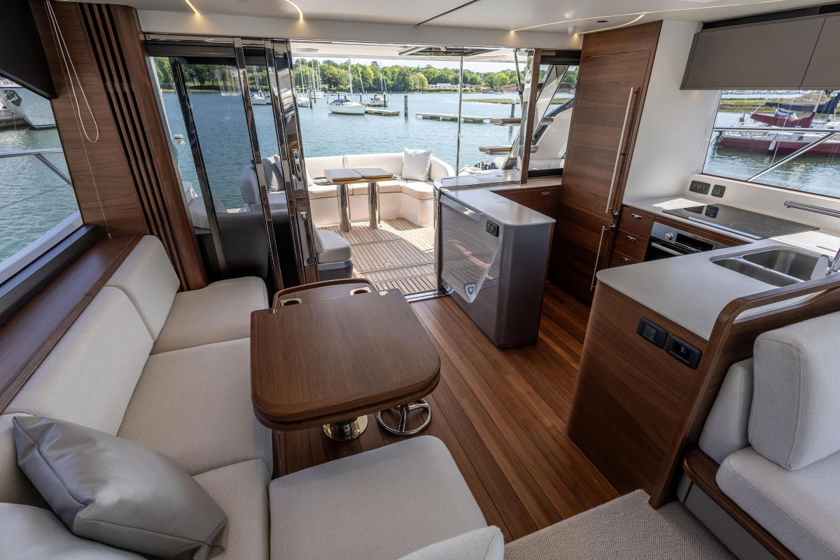 Luxurious interior of 2025 Princess S65 yacht with modern kitchen and seating area.