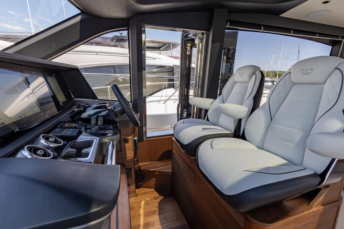Luxurious interior of 2025 Princess S65 yacht with modern helm and plush seating.