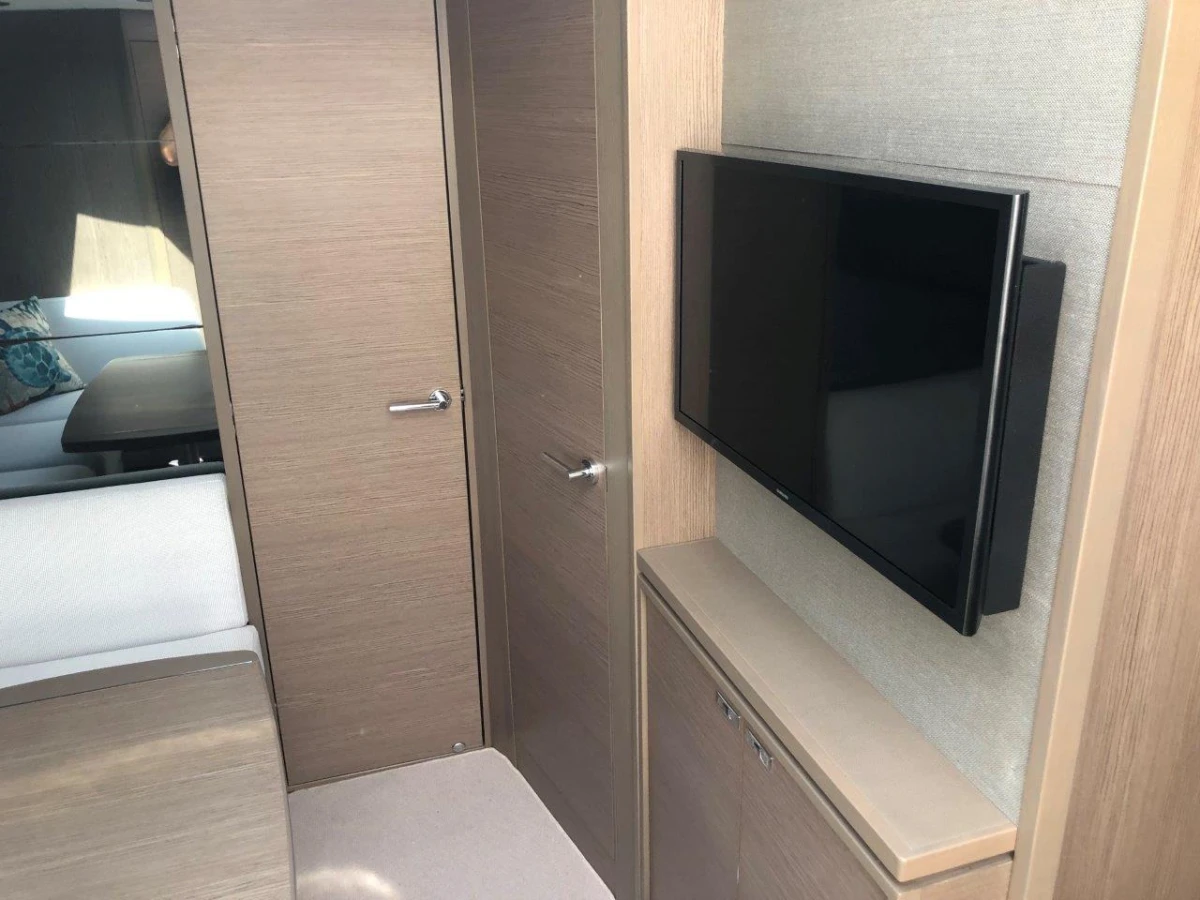 Modern interior of 2022 Princess V40 yacht with wall-mounted TV and sleek wooden finishes.