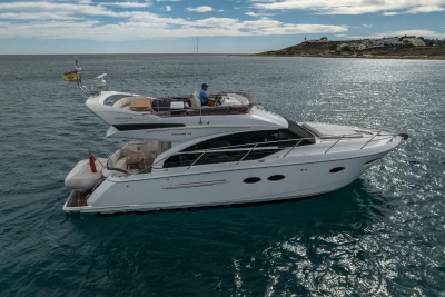 2018 Princess 43 yacht cruising on serene waters under a partly cloudy sky.