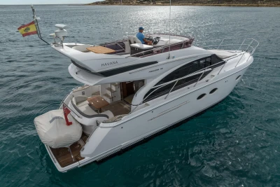 Luxurious 2018 Princess 43 yacht cruising on open water, featuring elegant design and spacious deck.
