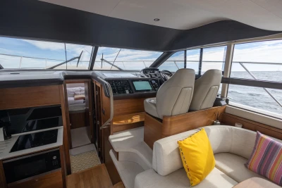 Interior of 2018 Princess 43 yacht with modern helm and cozy seating area.